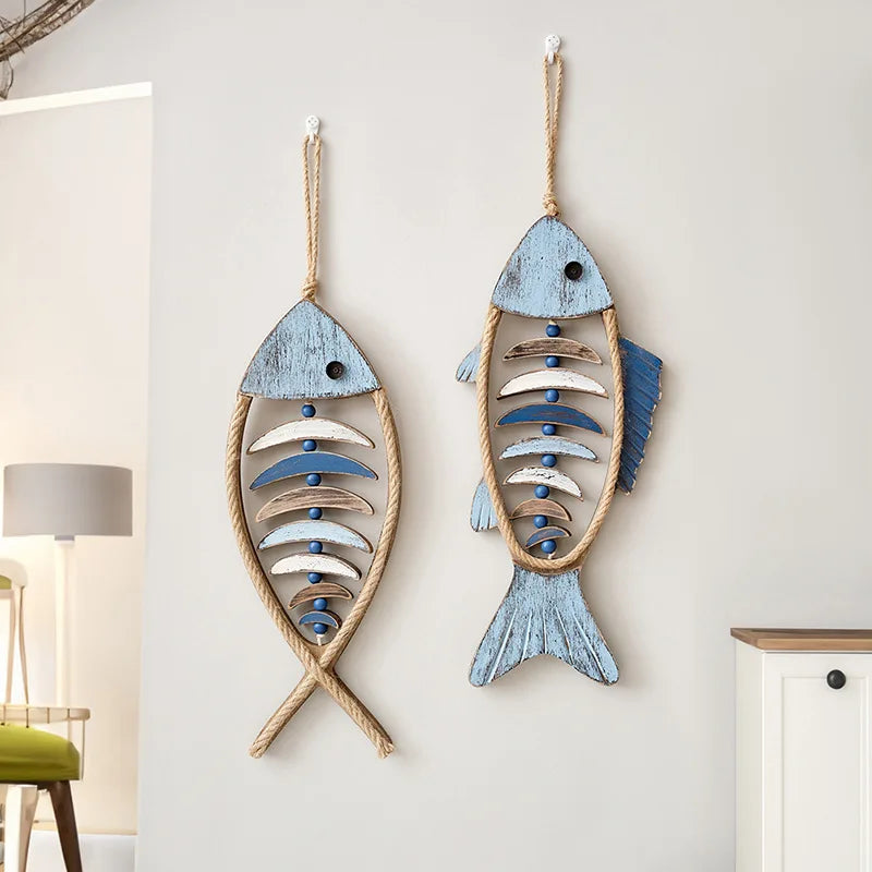 Two wooden fish wall decorations hanging on a light gray wall. boho home decor, coastal home accents, nautical wall hanging, wooden fish wall decor, Mediterranean decor, beach house decoration, rustic fish ornament, vintage boho living room decor, seaside wall art, summer housewarming gift