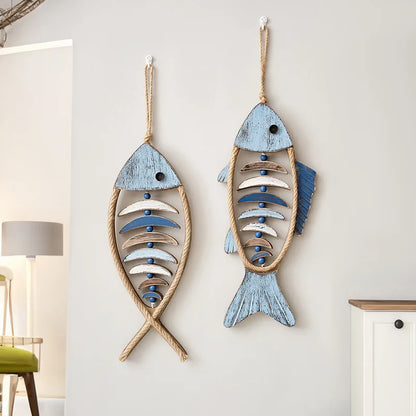 Two wooden fish wall decorations hanging on a light gray wall. boho home decor, coastal home accents, nautical wall hanging, wooden fish wall decor, Mediterranean decor, beach house decoration, rustic fish ornament, vintage boho living room decor, seaside wall art, summer housewarming gift