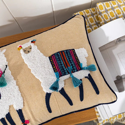 Decorative pillow with llama design on a wooden surface.Bohemian embroidered throw pillow cover with geometric design, cotton-blend cushion for sofa, bed, or modern home decor.