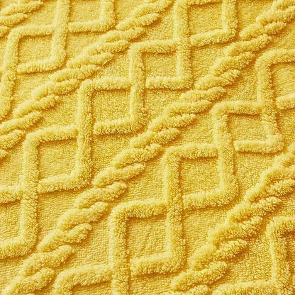 Close-up of a textured yellow fabric with geometric pattern. Soft plush duvet cover and blanket in solid color with striped jacquard design, dual-use artificial cashmere fleece bedding for cozy winter warmth