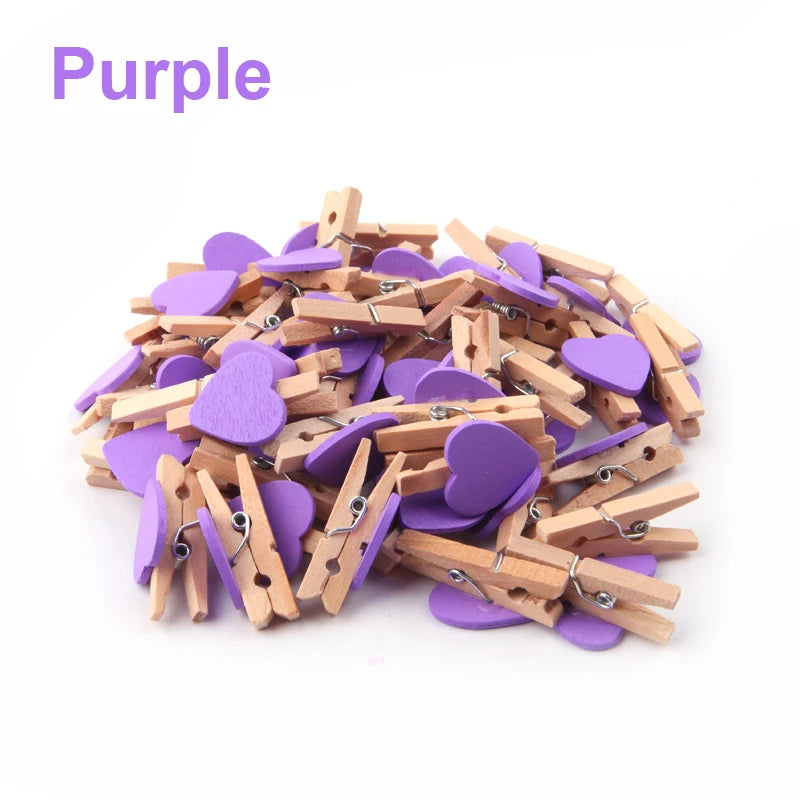 Purple heart-shaped and wooden clothespins on a white background