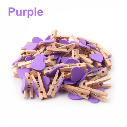 Purple heart-shaped and wooden clothespins on a white background
