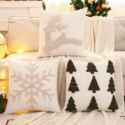 Decorative pillows with reindeer, snowflake, and tree patterns on a couch. Christmas embroidered pillow cover with tufted snowflake and reindeer design in 18x18 inches, festive canvas cushion case for sofa or bed