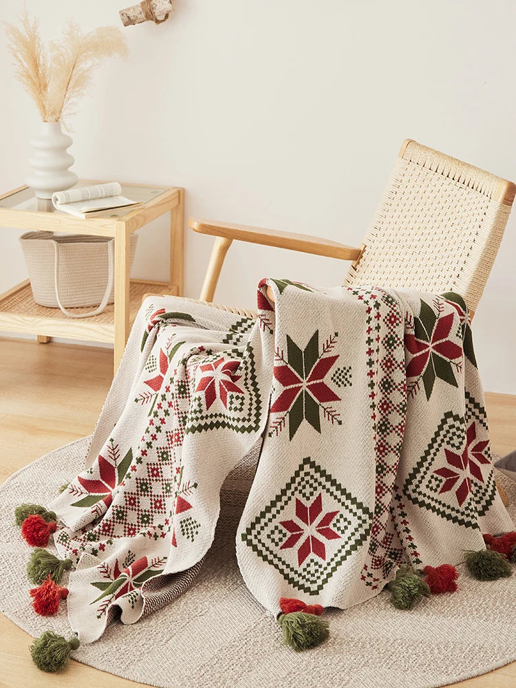 Decorative blanket with geometric patterns draped over a chair in a home setting.