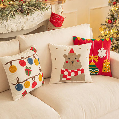 Decorative Christmas pillows on a couch with festive decorations in the background.