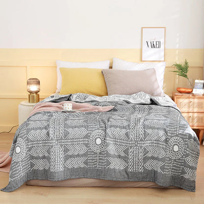 Bed with gray patterned comforter, pillows, and nightstands in a bedroom setting. Boho Lightweight microfiber summer blanket for bed or sofa, cooling breathable throw for home, dorm, or office naps with geometric jacquard pattern.