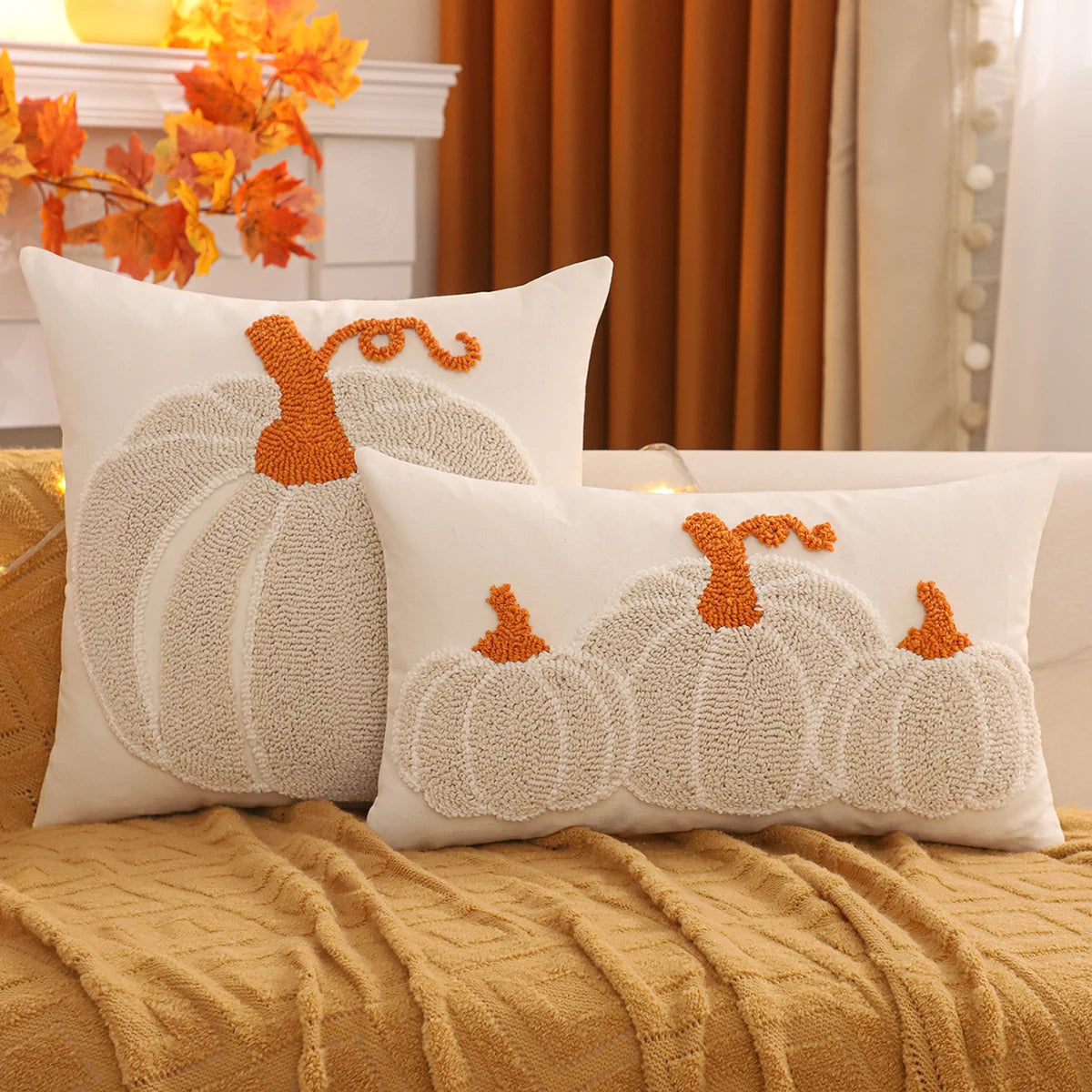 Decorative pillows with pumpkin designs on a couch in a cozy living room setting. Festive fall pillow cover for Halloween and Thanksgiving décor