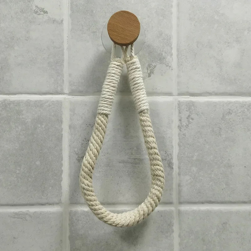 Wooden hook with a rope on a tiled wall. Boho rope toilet paper holder, nail-free wall mounted paper towel rack, rustic bathroom storage and decor accessory with wood and rope design