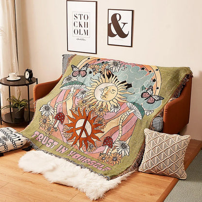Decorative blanket with sun and moon design on a couch in a living room. Trust In Yourself Boho Blanket