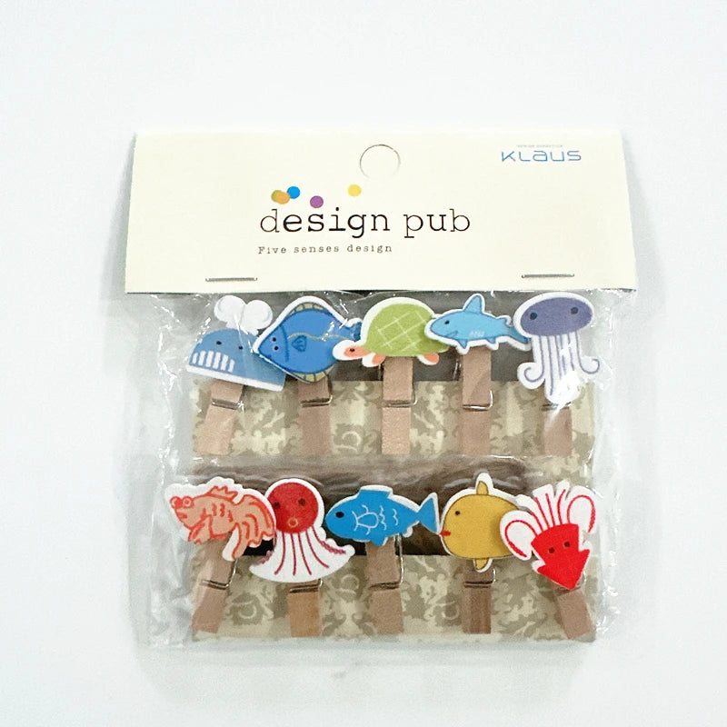 Packaged set of colorful wooden clips with animal designs on a white background