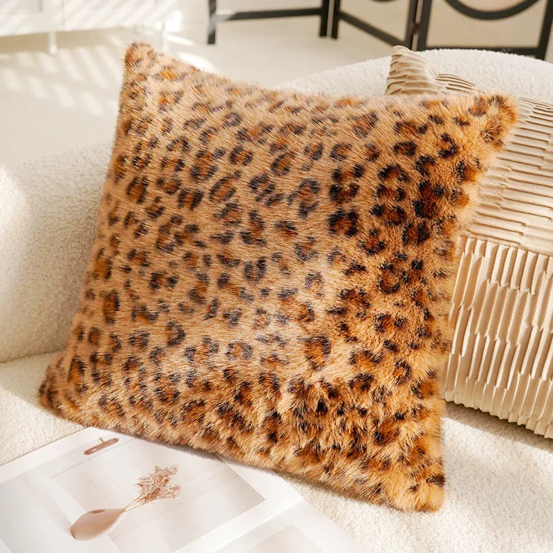 Leopard print pillow on a white sofa with a decorative box in the foreground.