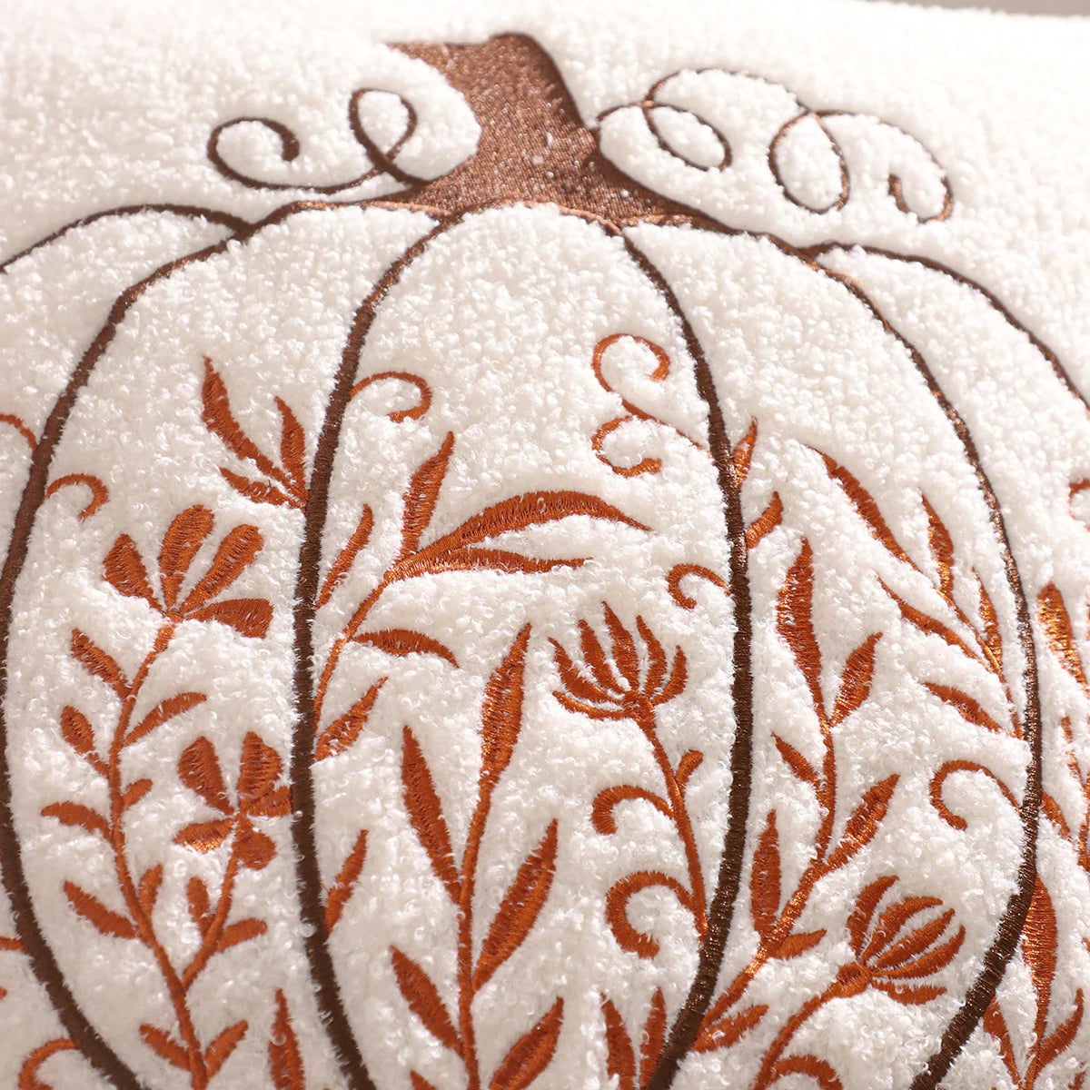 Decorative white pumpkin with brown floral patterns on a textured beige background. fall boho pillow throw gift ideas