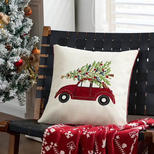 Decorative pillow with a Christmas tree and red car design on a black chair next to a Christmas tree. Christmas gold letter embroidered pillow cover with “Holly Jolly” and snowflake design, soft red and white chenille cushion case for sofa or living room holiday décor.