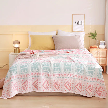Bed with a patterned quilt, pillows, and nightstands in a bedroom setting. Boho Lightweight microfiber summer blanket for bed or sofa, cooling breathable throw for home, dorm, or office naps with geometric jacquard pattern.