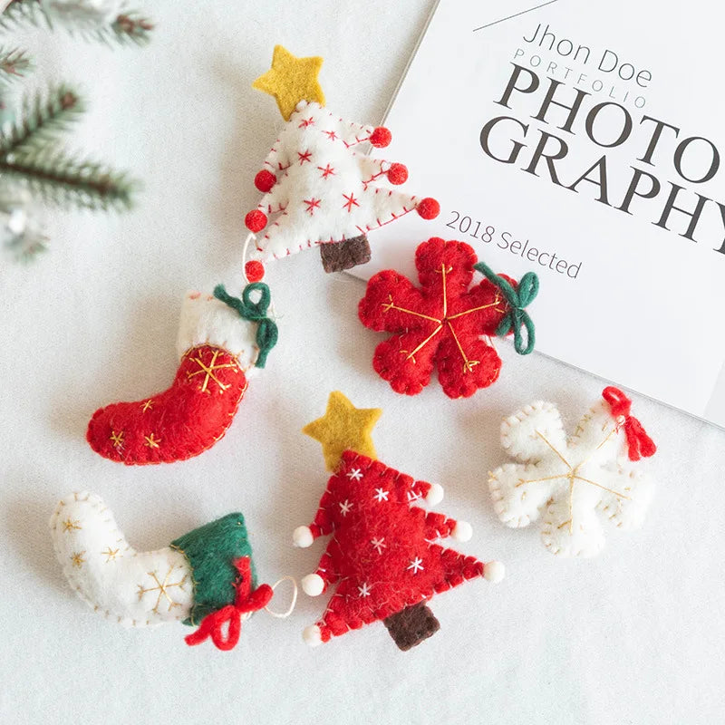 Felt Christmas ornaments on a white surface with a photography portfolio book in the background.