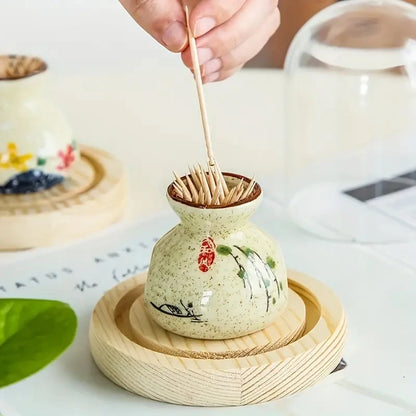 Ceramic toothpick holder with wooden lid on a white surface
