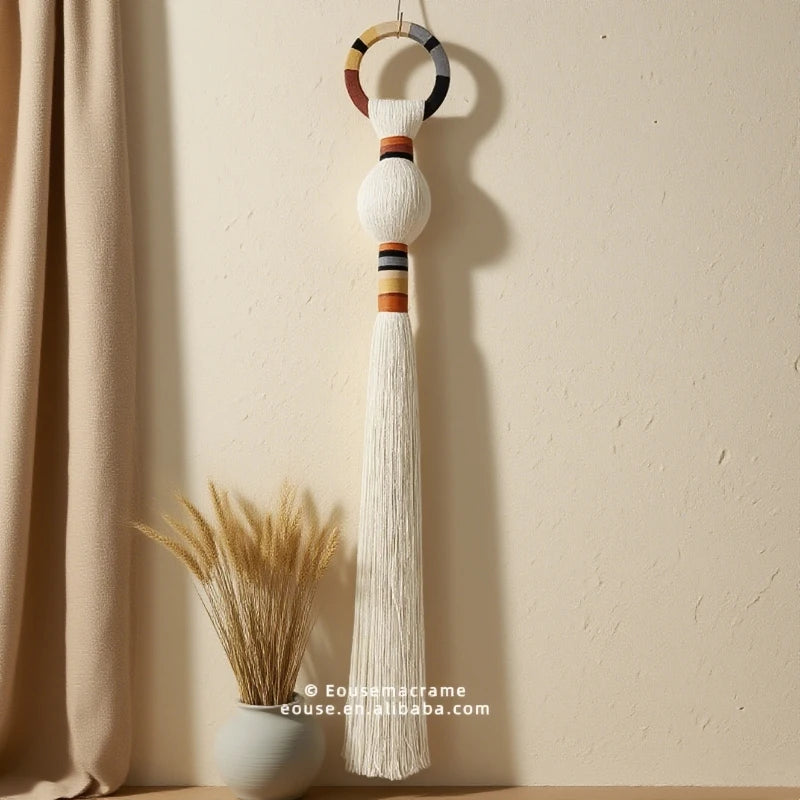 Decorative tassel with beads hanging against a beige wall. boho macrame wall art