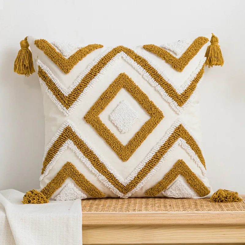 Decorative pillow with geometric pattern and tassels on a wooden surface. Nordic blue tufted cushion cover with geometric stripe and grid crochet pattern, tassel pillow cover for sofa, bed, and boho home decor