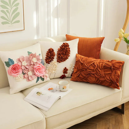 Decorative pillows on a sofa with a cup and notebook. French style floral embroidered patchwork pillow cover for sofa decor