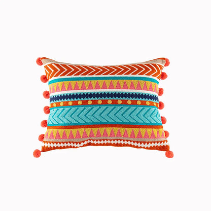 Colorful patterned pillow with pom-pom details on a white background. Bohemian embroidered throw pillow cover with geometric design, cotton-blend cushion for sofa, bed, or modern home decor.