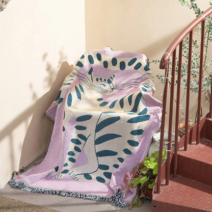 Decorative blanket with leaf pattern draped over a chair on a staircase. Pink cat cartoon throw blanket boho cotton sofa cover
