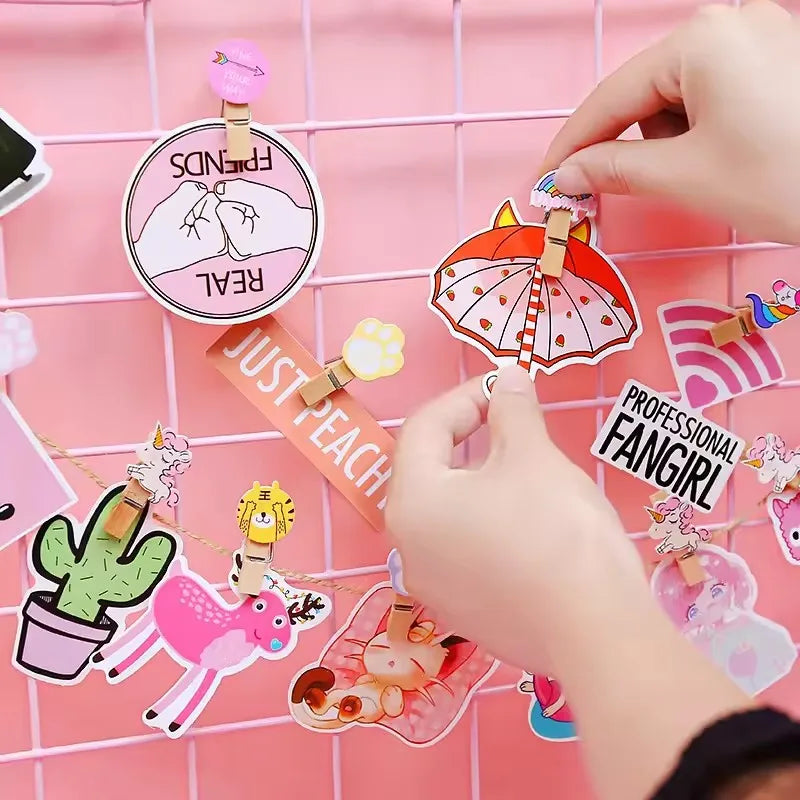 Hand arranging various decorative stickers on a pink grid background