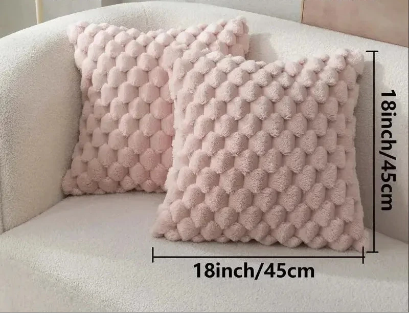 Pink textured pillow covers on a white sofa with dimensions displayed.