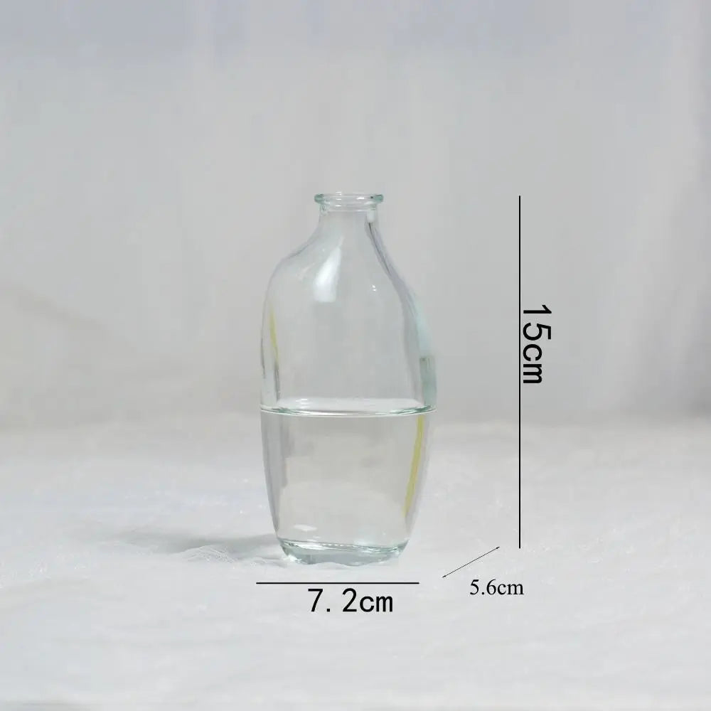 Clear glass bottle with water, measurements indicated on a white background