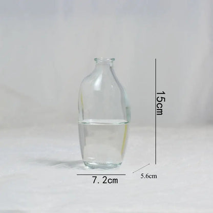 Clear glass bottle with water, measurements indicated on a white background