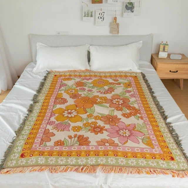 Floral patterned throw blanket on a bed in a bedroom setting. Mediterranean style woven cotton throw blanket boho home decor