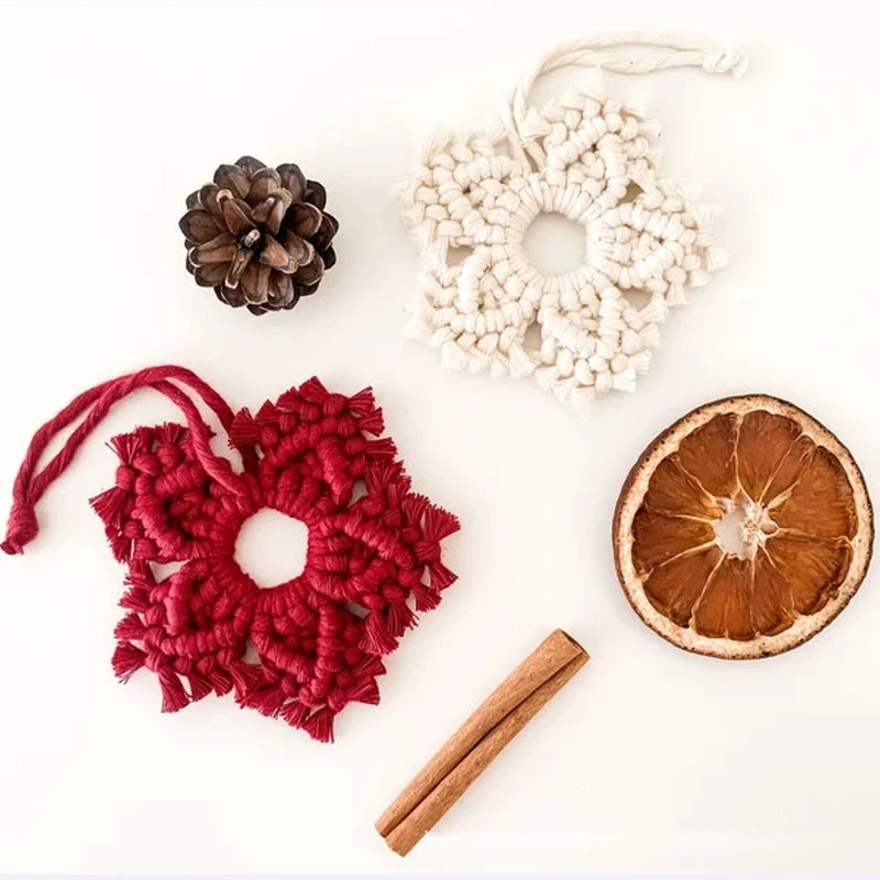 Decorative items including a red woven heart, pine cone, white lace wreath, cinnamon stick, and dried orange slice on a white background.