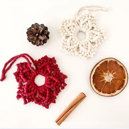 Decorative items including a red woven heart, pine cone, white lace wreath, cinnamon stick, and dried orange slice on a white background.