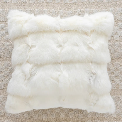 White fur rug on a beige carpet. embroidery throw pillow cover in boho modern style
