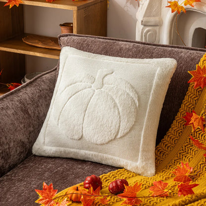 White pillow with pumpkin design on a brown couch with autumn decorations. Halloween pumpkin plush pillow cover for sofa and bed decor.