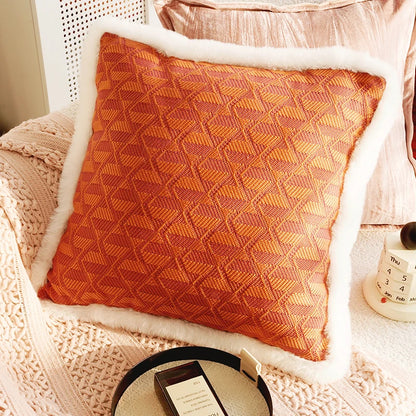 Orange textured pillow on a white chair with a pink blanket. Boho Home Decor. 