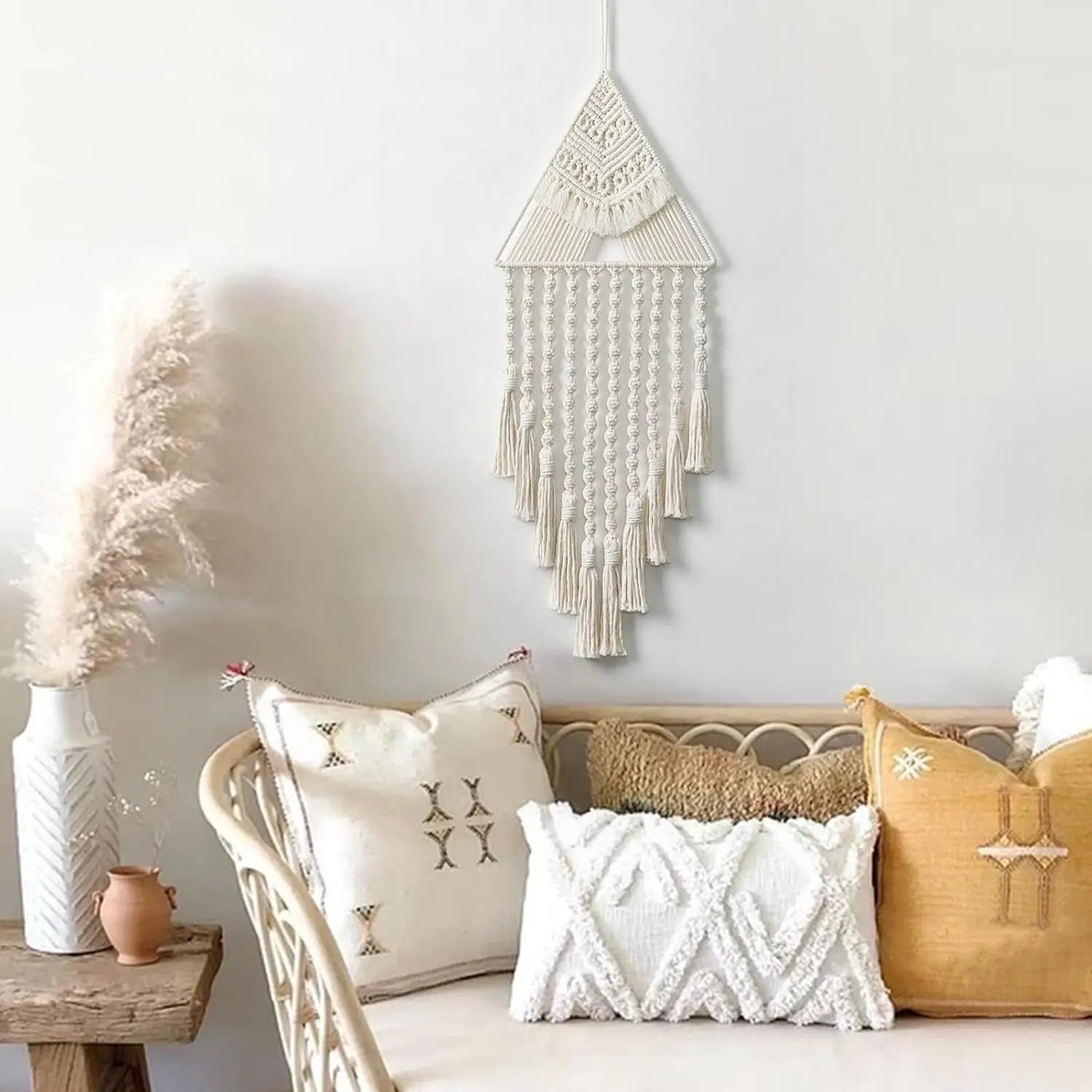 Decorative wall hanging above a sofa with patterned cushions in a living room setting. boho home decor, macrame wall hanging, triangle dream catcher, woven tapestry, handmade cotton wall decor, tassel wall hanging, bedroom door decor, housewarming gift, rustic bohemian art, boho apartment wall decor, neutral textile art