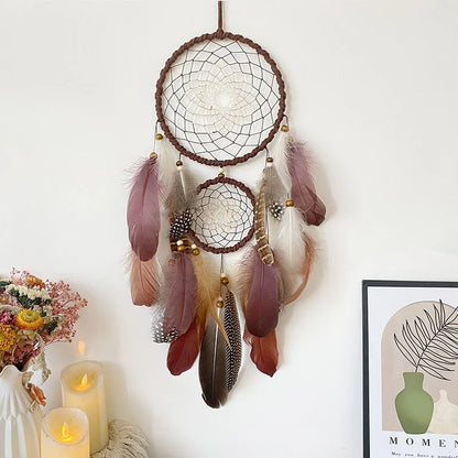 Dreamcatcher with feathers hanging on a white wall with candles and decor. boho home decor, housewarming gift, dream catcher wall hanging, feather wind chime, handmade dreamcatcher, colorful boho wall decor, birthday gift decor, modern bohemian style, bedroom hanging ornament, spiritual home decor, dreamcatcher nursery decor