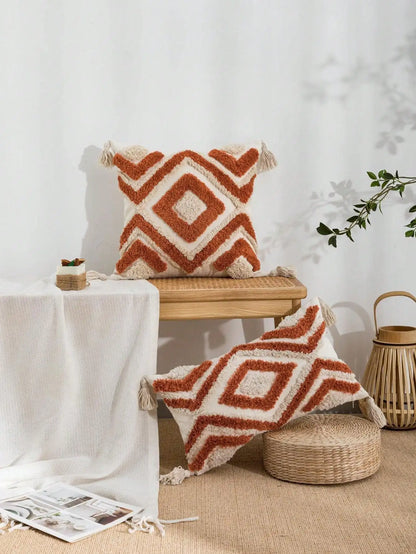 Decorative pillows with geometric patterns on a wooden stool and floor against a white wall. Nordic Moroccan tufted throw pillow cover in geometric jacquard design, boho accent cushion for sofa, bed, or car, available in 12x20 inch lumbar and 18x18 inch square sizes – cozy textured boho home decor.