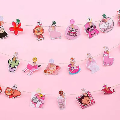 String of cartoon character wooden clips on a pink background