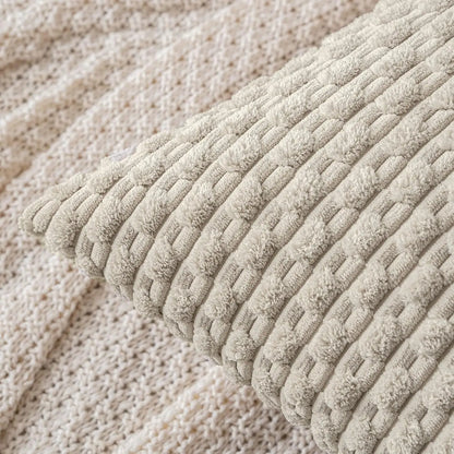 Close-up of a textured beige pillow with a woven pattern.