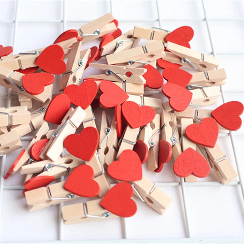 Wooden clothespins with red heart-shaped attachments on a white background