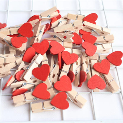 Wooden clothespins with red heart-shaped attachments on a white background