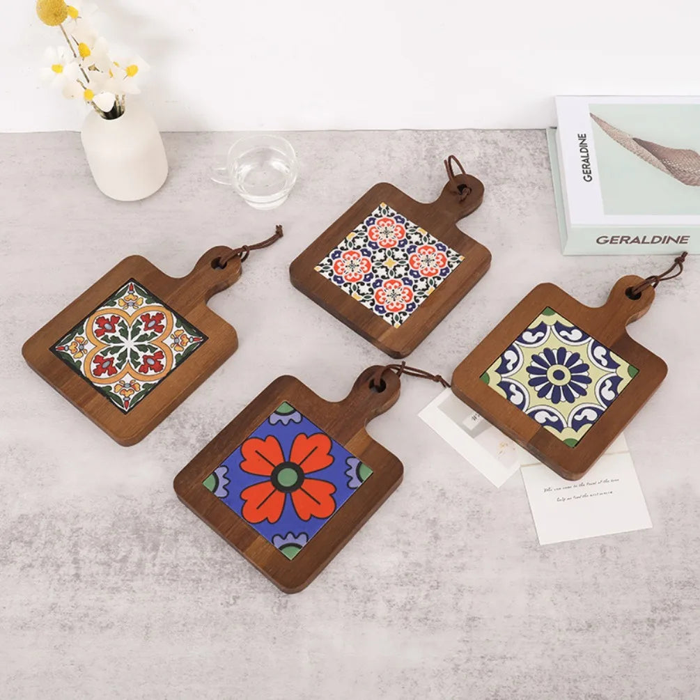 Set of four wooden coasters with colorful tile designs on a light surface.