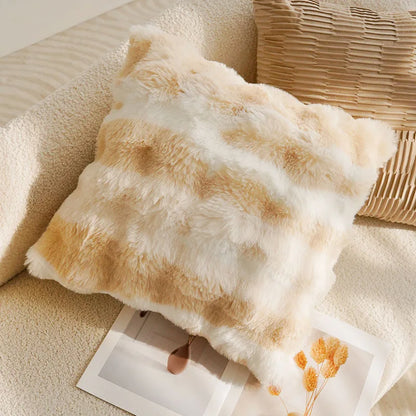 Fluffy beige pillow on a textured surface with a blurred background