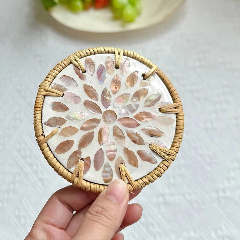Round boho coaster with shell inlay held by a hand on a light background