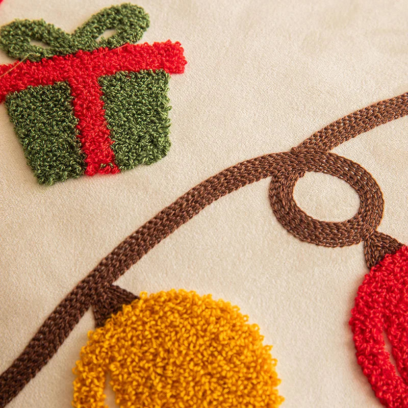 Close-up of a textured surface with decorative elements including a green and red gift box, brown arch, yellow ball, and red circular shapes.