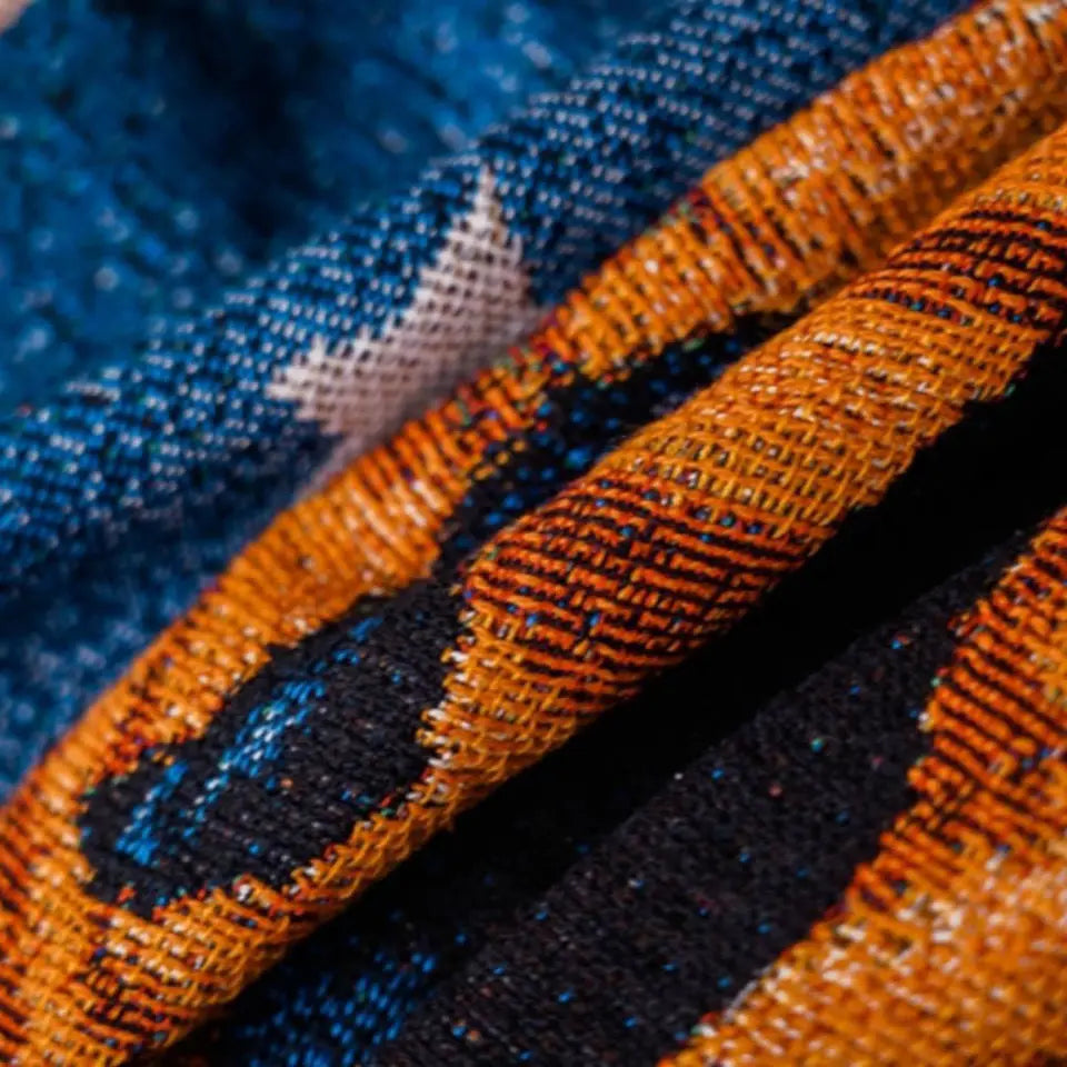Close-up of blue and orange fabric with a textured pattern Halloween black cat and pumpkin throw blanket, woven spooky tapestry for autumn decor