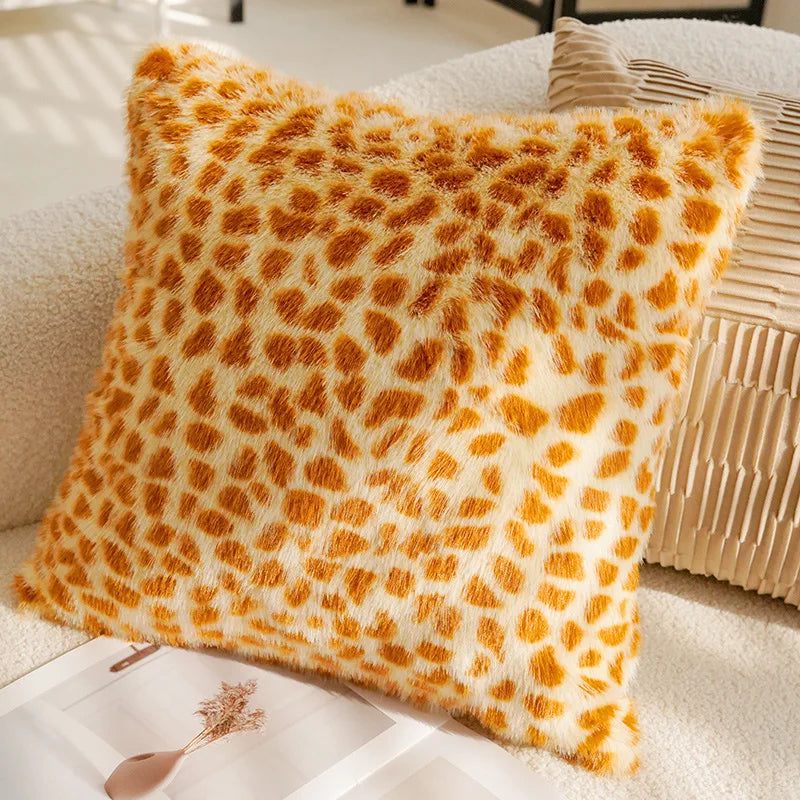 Leopard print pillow on a beige sofa with a magazine underneath