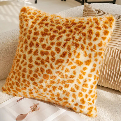 Leopard print pillow on a beige sofa with a magazine underneath