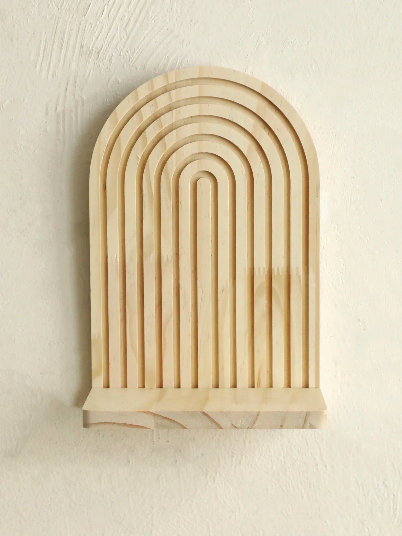 Wooden wall art with arch design on a beige background